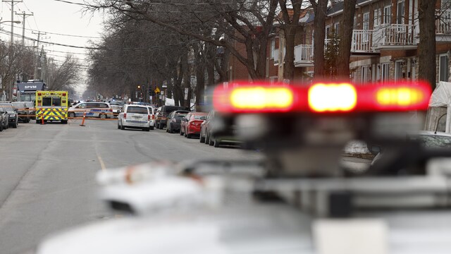 Des gyrophares de police flous au premier plan d'une scène de crime.