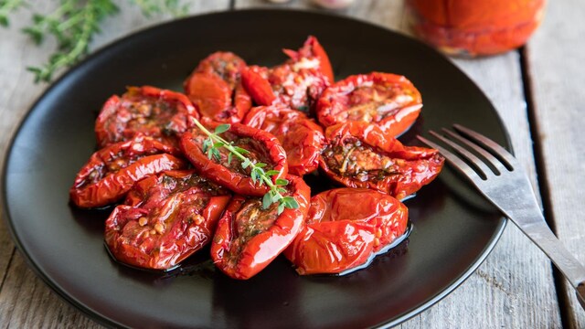 Une assiette avec une douzaine de tomates confites.