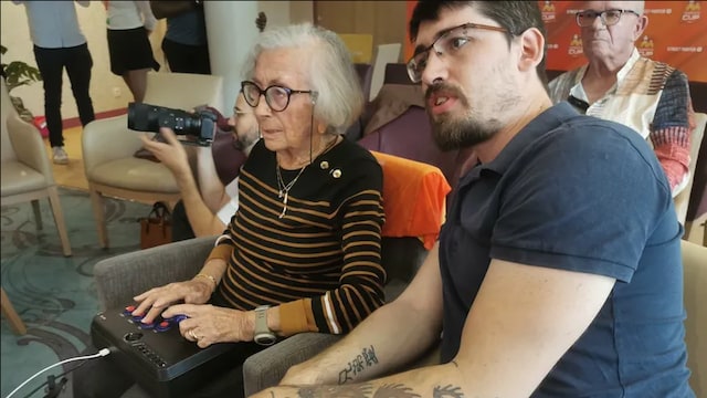 Germaine (95 ans) et son co-équipier Jean-Louis (trentaine) jouent un jeu vidéo.
