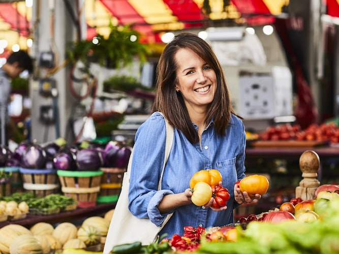La nutritionniste Geneviève O'Gleman se trouve au marché avec des tomates dans les mains.