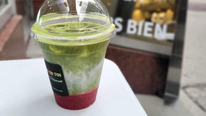 A green and pink drink in a plastic glass. boom du matcha, double -edged
