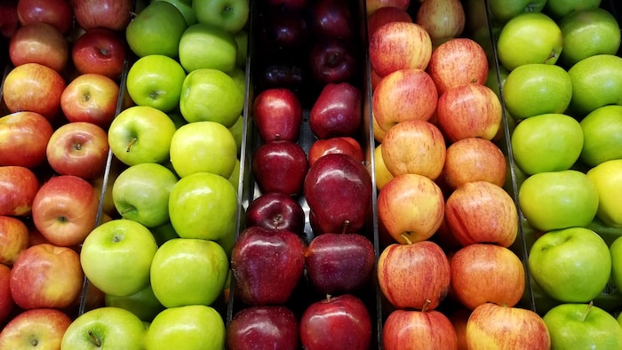 Un étal avec plusieurs variétés de pommes.