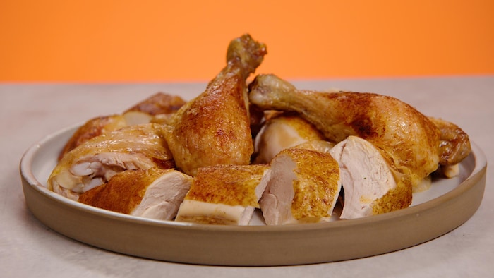 Une assiette avec des ailes, des cuisses, des poitrines et des pilons de poulet cuits. 