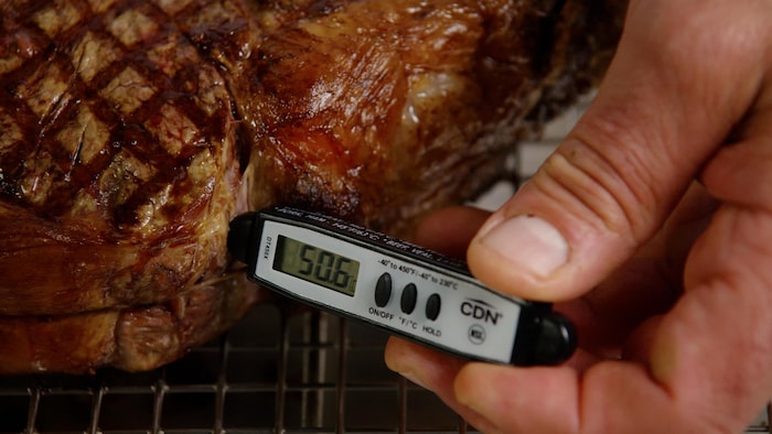 Un thermomètre à viande dans un steak.
