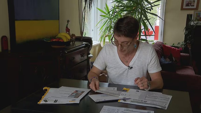 Une femme observant son bulletin de vote référendaire.