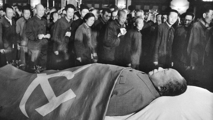 Dans une salle, des personnes se trouvent près du corps de Mao Zedong.