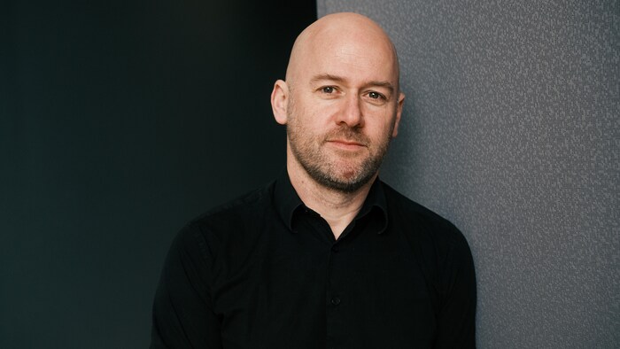 Il sourit au photographe. 