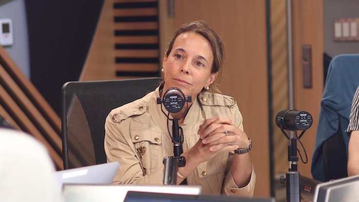 She speaks behind a microphone on the radio.