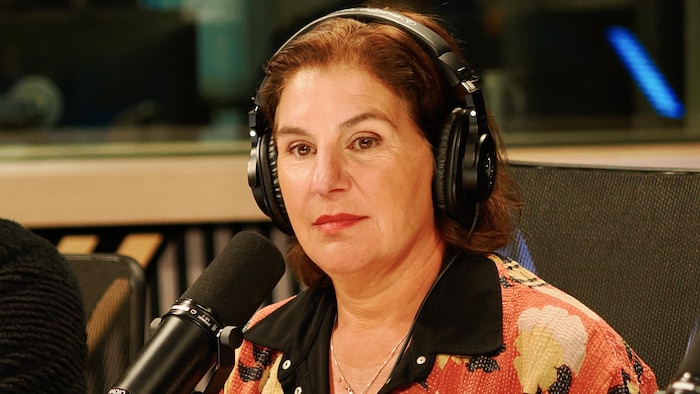 Joanne Comte-Btesh est assise en studio et porte des écouteurs.