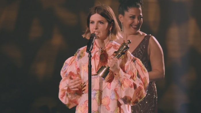 Klô Pelgag parle dans un micro en tenant un prix dans sa main gauche.