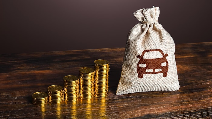 De l'argent et un sac sur lequel figure une image de voiture.