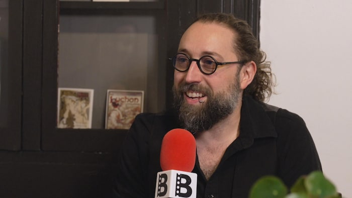 Jonathan Roy tient un micro durant une entrevue.