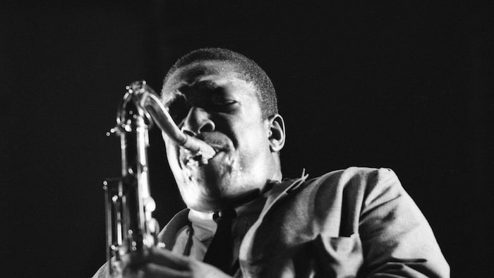 Un musicien souffle dans son saxophone.