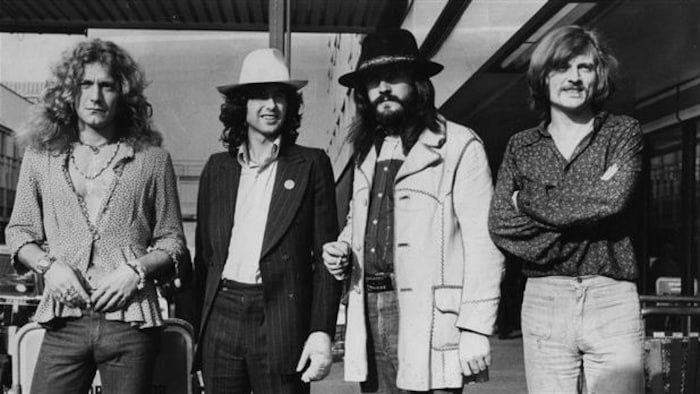Les quatre membres du groupe Led Zeppelin posent à la sortie d'un avion.