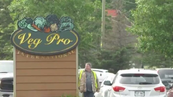 L'entrée de la ferme avec une pancarte sur laquelle on peut lire le nom de l'entreprise : Vegpro International.