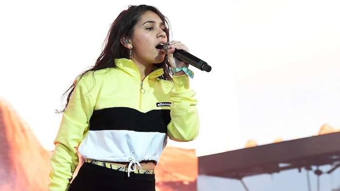 Alessia Cara chante dans un micro.