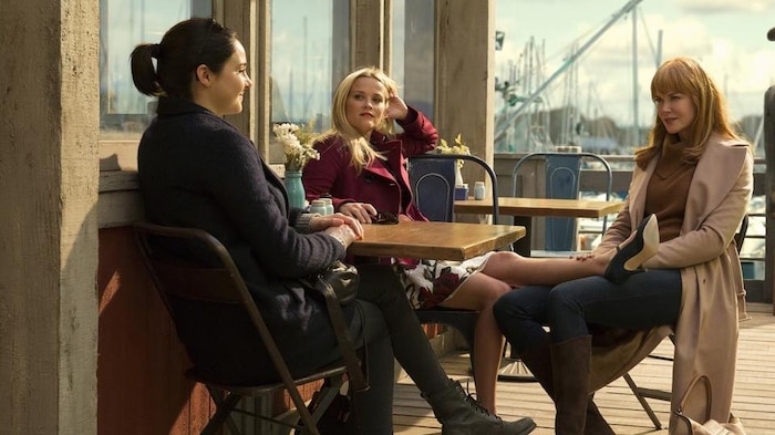 Les trois femmes sont autour de la table d'un café, à l'extérieur.
