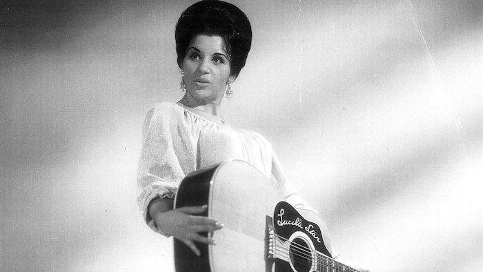 Lucille Starr qui tient une guitare.