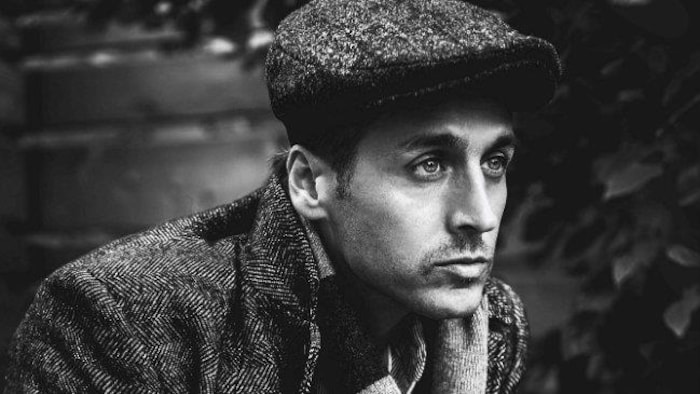 Portrait du chanteur coiffé d'un béret.