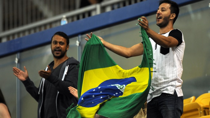 Des amateurs agitent un drapeau du Brésil dans les gradins.