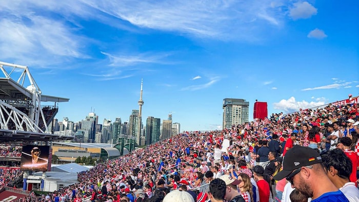 Des fans de soccer dans un stade avec Toronto en arrière plan.