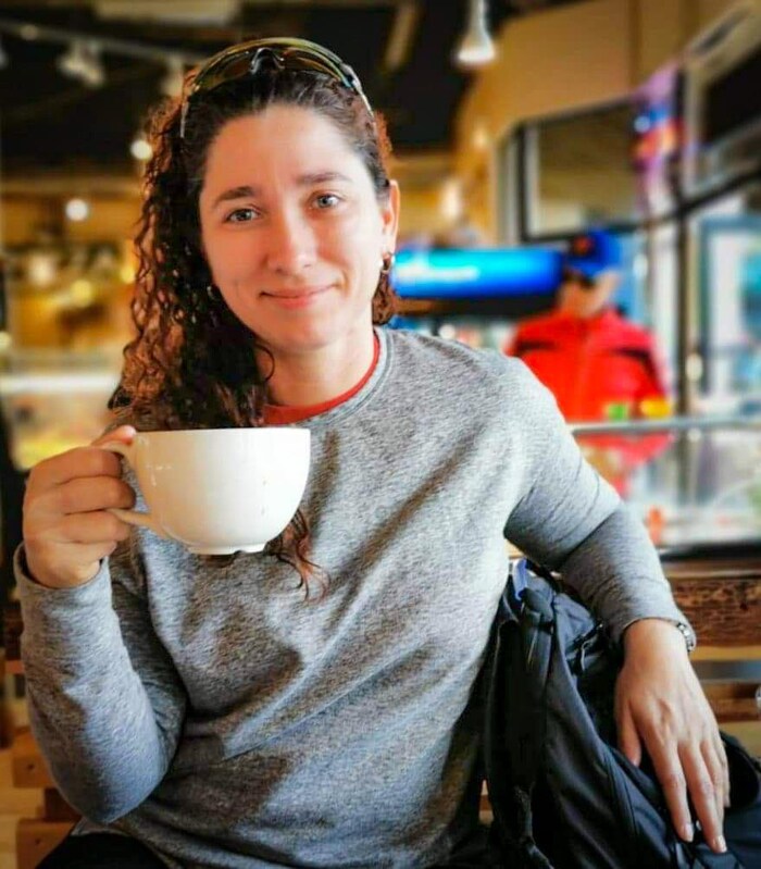 Une femme avec une tasse du cafe dans la main.