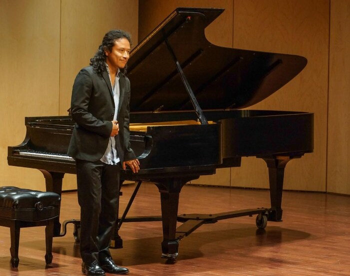 Un homme devant un piano.