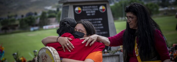 Katherine Cooper de la Première Nation crie Mosakahiken au Manitoba conforte une amie devant un mémorial en honneur des enfants autochtones enterrés à Kamloops.