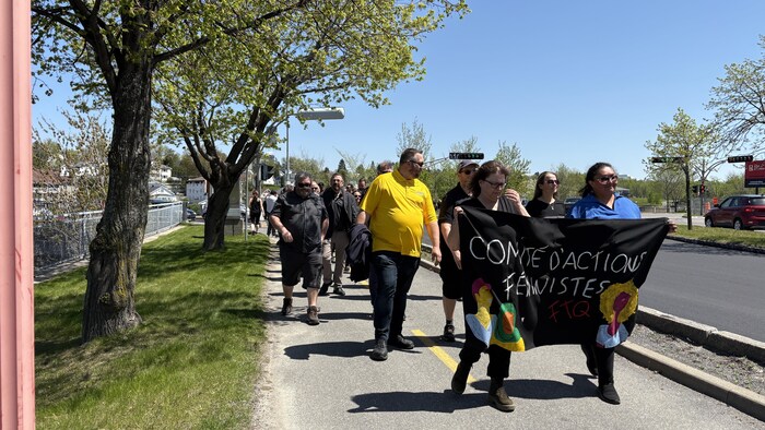 Des personnes participent à une marche dans les rues d'Alma.