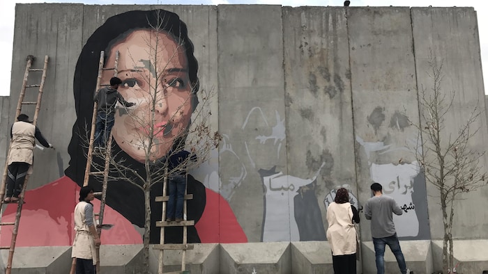 Des personnes peignent une murale.
