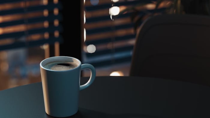 Une tasse de café sur une table de nuit.