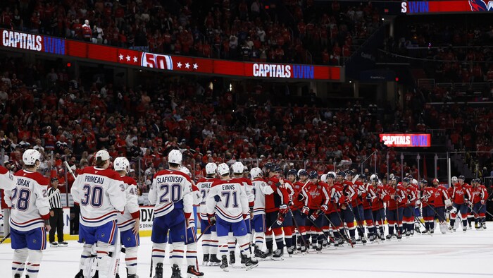 Une poignée de mains entre les deux équipes à la fin d'un match de hockey.