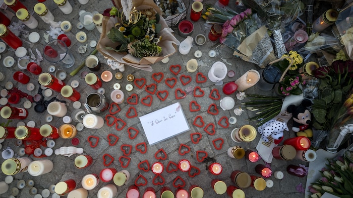 Des fleurs, des coeurs, des lampions et de messages de solidarité sur le sol.