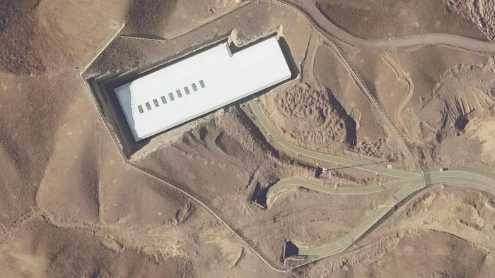 Image satellite d'un seul batîment entouré de routes et d'entrées de tunnels.
