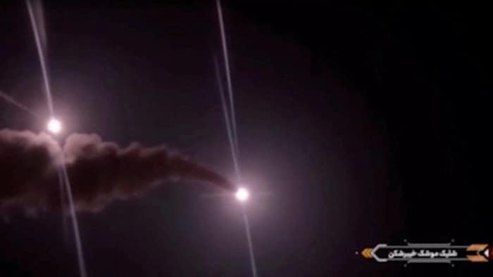 Deux points lumineux suivis de traînées de fumée dans le ciel.