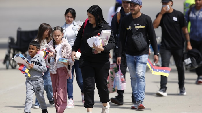 Men, women and children walk on an landing track. american court allows expulsion migrants american court allows expulsion migrants new