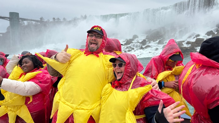 Des personnes déguisés en soleil devant les chutes Niagara.
