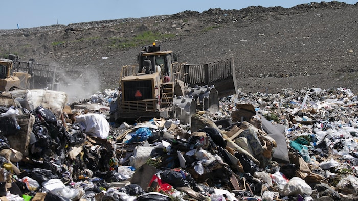 Un camion étend des sacs d'ordures.