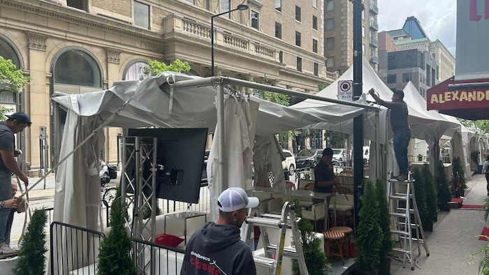 Des chapiteaux en train d'être démontés sur des terrasses.