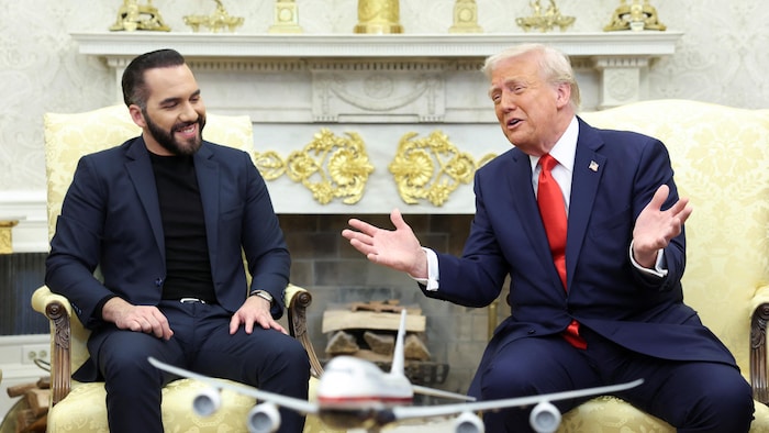 Deux hommes, assis dans des fauteuils, rigolent.