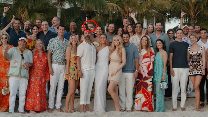 Un groupe de personnes pose sur une plage. Un cercle rouge ajouté sur la photo montre la tête d'Umar Kremlev, en arrière-plan.