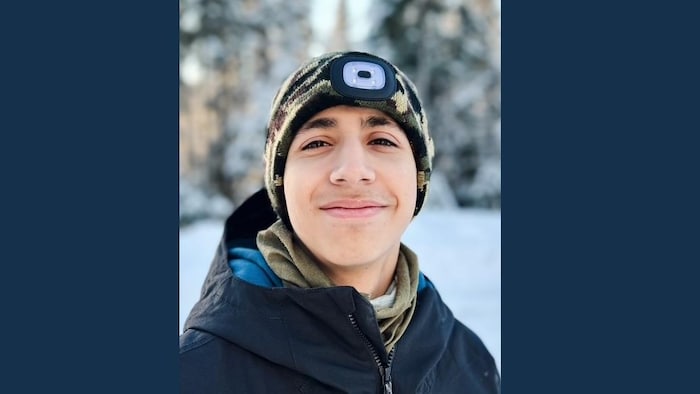 Photo d'un adolescent en habit hivernal lors d'une sortie de ski.