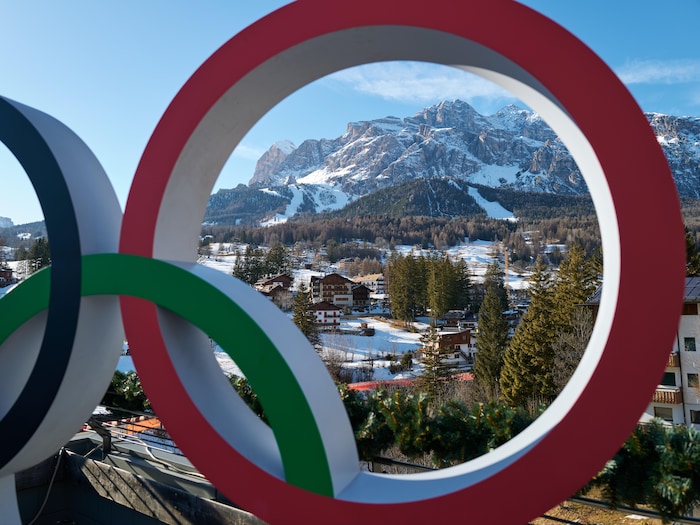 Une montagne et une piste de skis  derrière les anneaux olympiques.