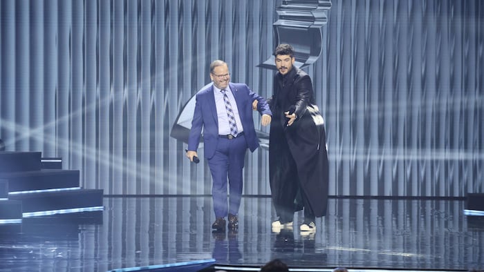 Les deux hommes sourient sur scène.