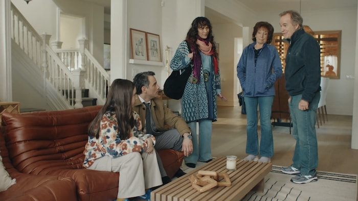 Une famille de cinq personnes dans un salon. 