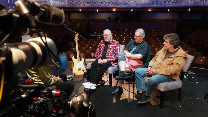 Pierre Robichaud, Ronald Dupuis et Roland Gauvin du groupe 1755, en entrevue sur la scène du théâtre Capitol.