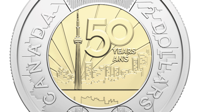Le centre de la pièce de 2 $ montre la Tour CN, 50 ans sont écrits à côté. L’anneau qui l’entoure a des motifs de l’horizon urbain de Toronto ainsi que des feuilles d’érable et il est écrit également la Tour CN.