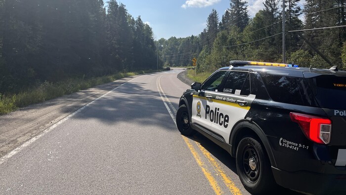Une voiture de police bloque la route en amont d'un accident.