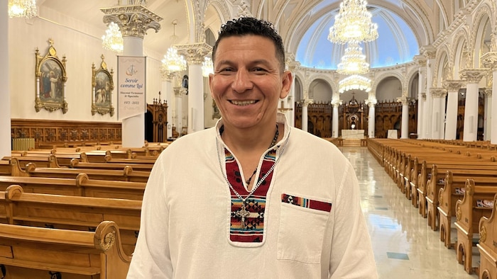 Un homme d'origine colombienne sourit  dans une église. 