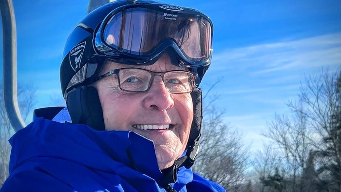 Un homme portant un casque, souriant 